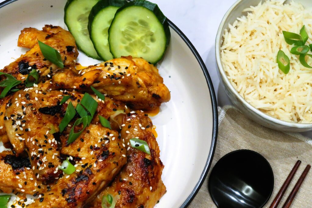 chicken wings served with rice and cucumber