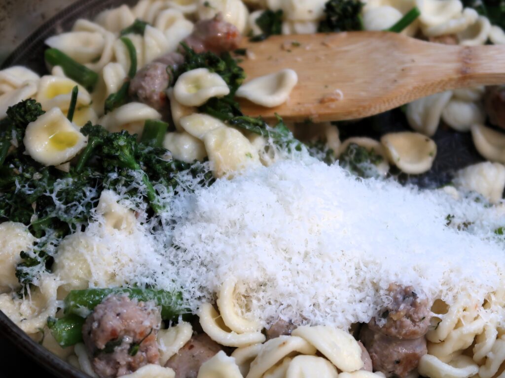 combining the orecchiette with the sausage, broccolini and pecorino