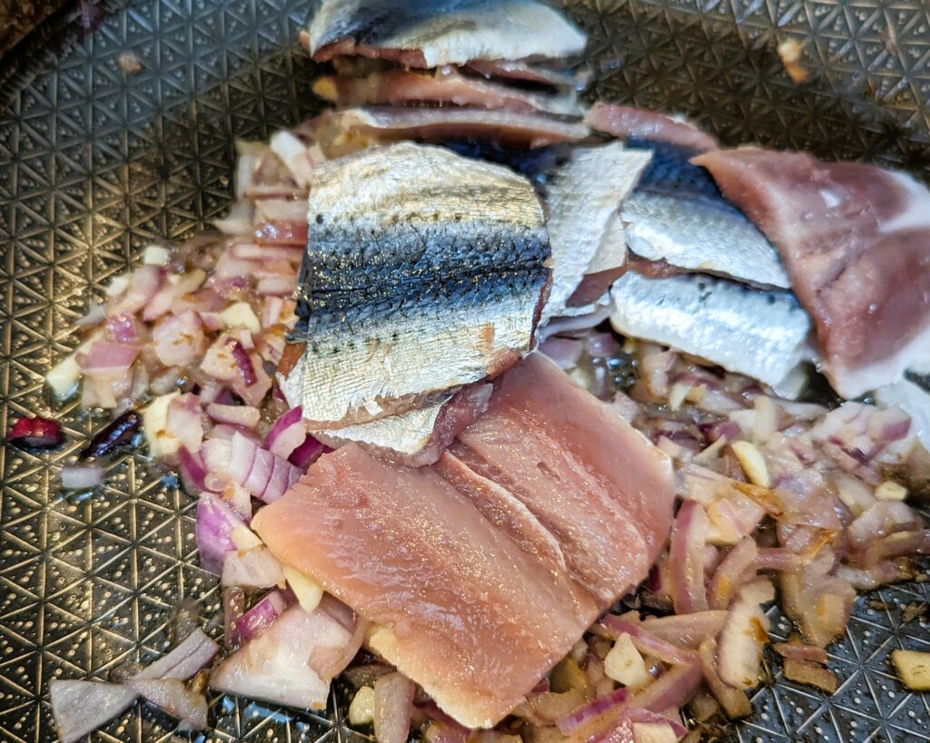 adding the sardines to the soffritto