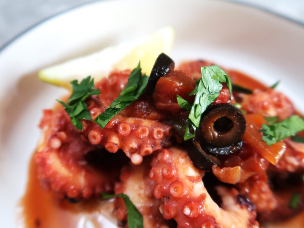 Pressure cooker octopus ready for serving with some fresh chopped parsley